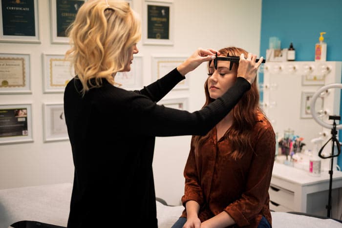Mary Katz mearsuring a client's face before performing permanent makeup at Beauty on Broadway